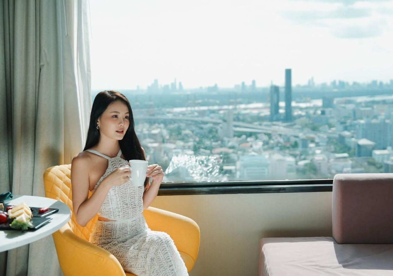 فندق أفاني سوكومفيت بانكوك المظهر الخارجي الصورة A woman drinking coffee
